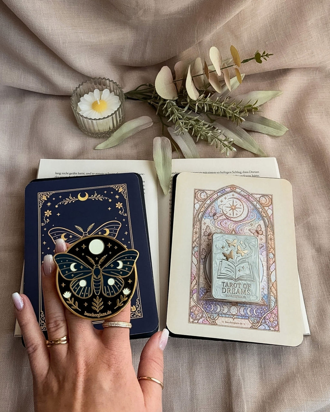 E-Reader Grips und Inserts von buecherglanz auf einem offenen Buch mit Enchanted Moth und Tarot-inspirierten Designs