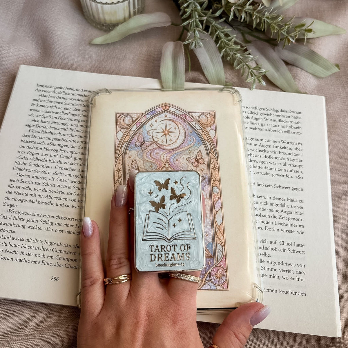 Divined Chapter Set: Hand hält den Grip an einem E-Reader in transparenter Hülle mit dem passenden Insert