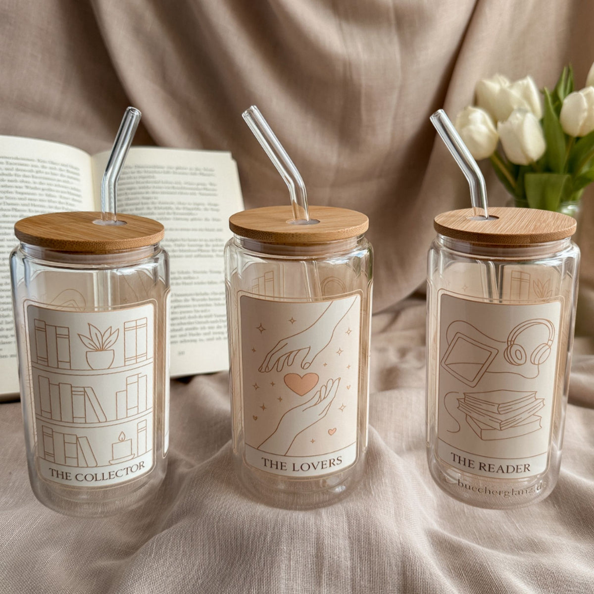 Doppelwandiger 16-oz-Glastumbler im Tarot-Design mit drei Tarotkarten neben offenem Buch und weißen Tulpen