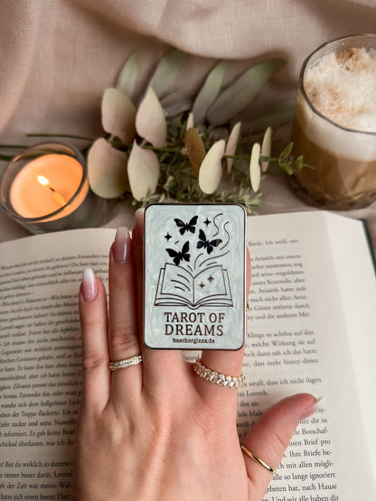 Tarot of Dreams Kindle Grip in Hand auf aufgeschlagenem Buch mit Kerze und Latte