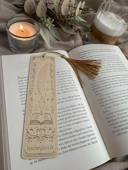 The Inksworn – Metall-Lesezeichen – Lifestyle liegend im Buch Goldquaste Kerze Warm Cozy, buecherglanz
