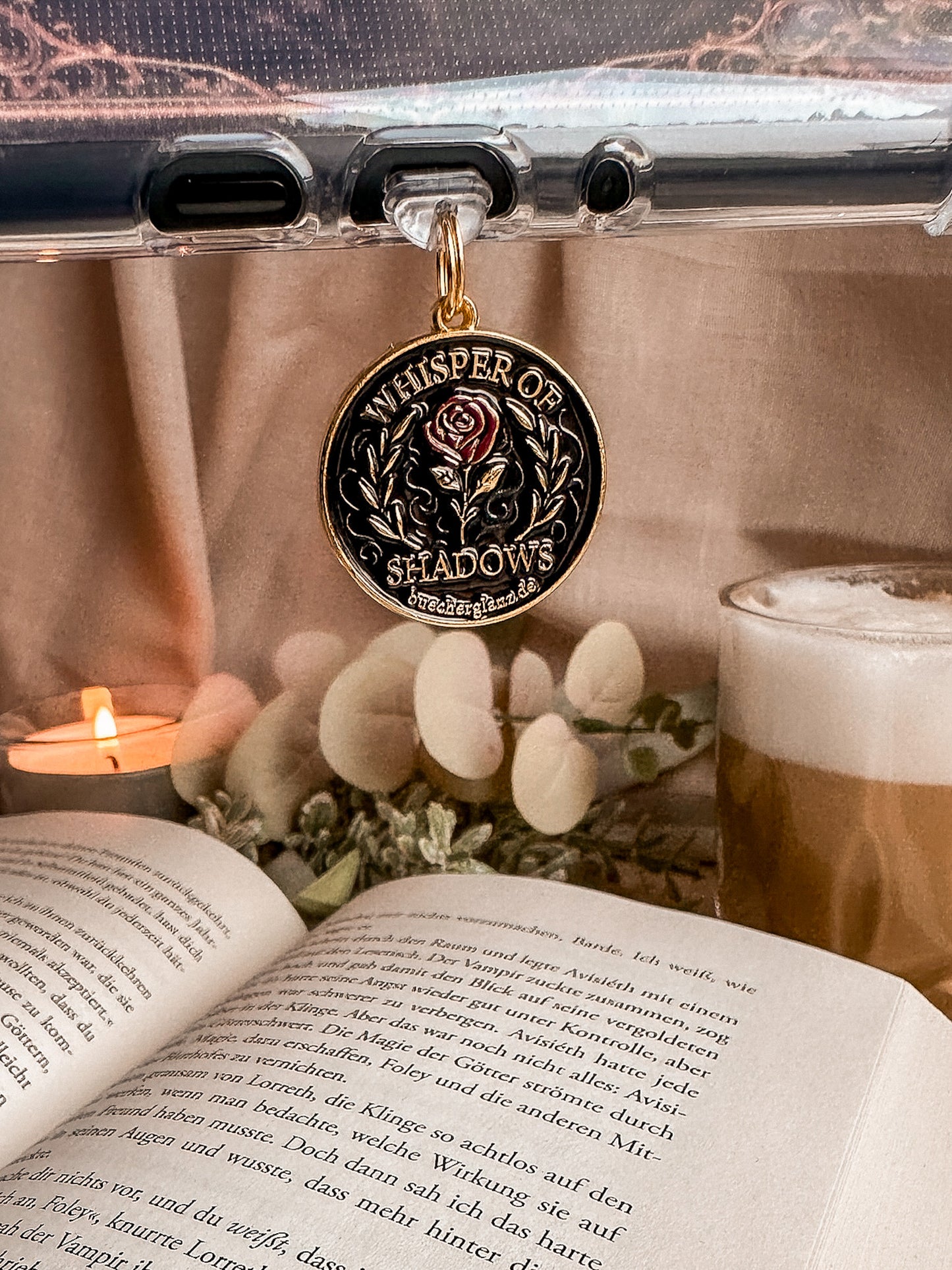 Whisper of Shadows – USB-C Dustplug – Lifestyle hängend am Kindle weiße Blumen Latte, buecherglanz