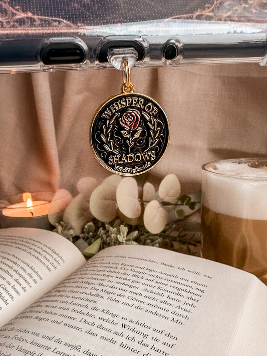 Whisper of Shadows – USB-C Dustplug – Lifestyle hängend am Kindle weiße Blumen Latte, buecherglanz